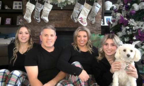 Lisa Swales-Stachow and family in front of stockings hung on mantle